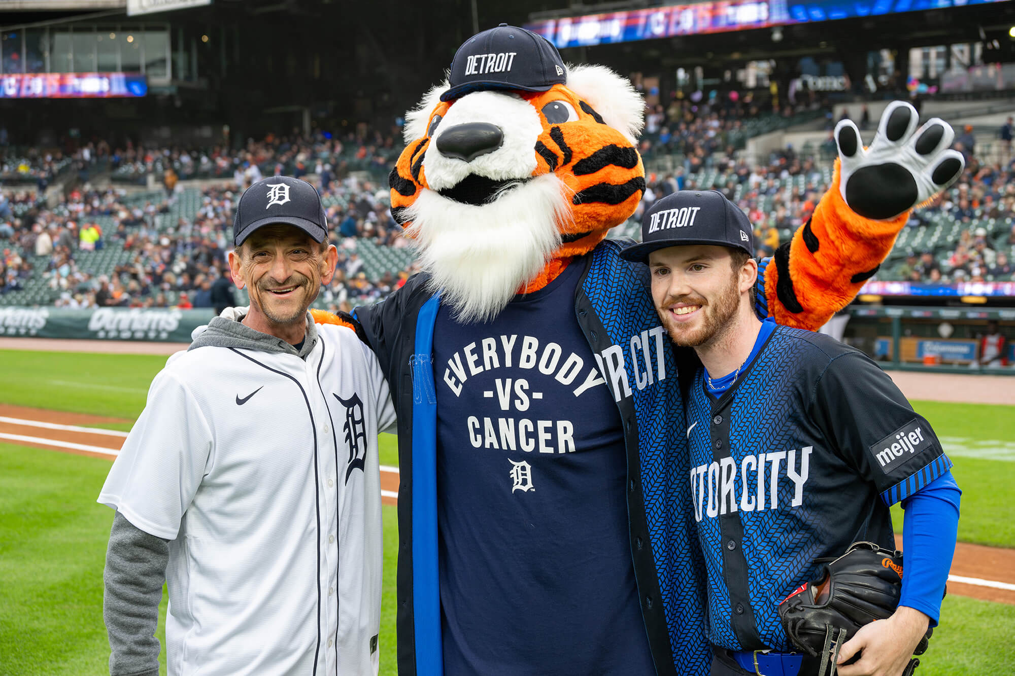 James Radeback, pancreatic cancer survivor, poses with Paws and a Detroit Tigers player.
