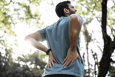 man rubbing lower back