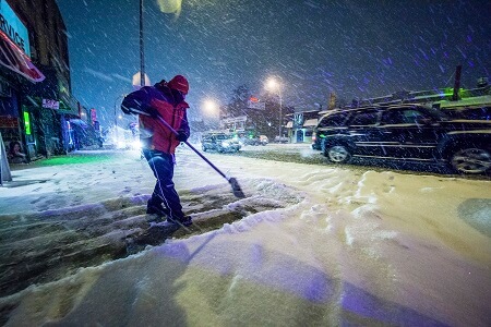 Man shoveling in snow storm