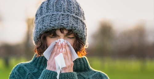 sick woman sneezing