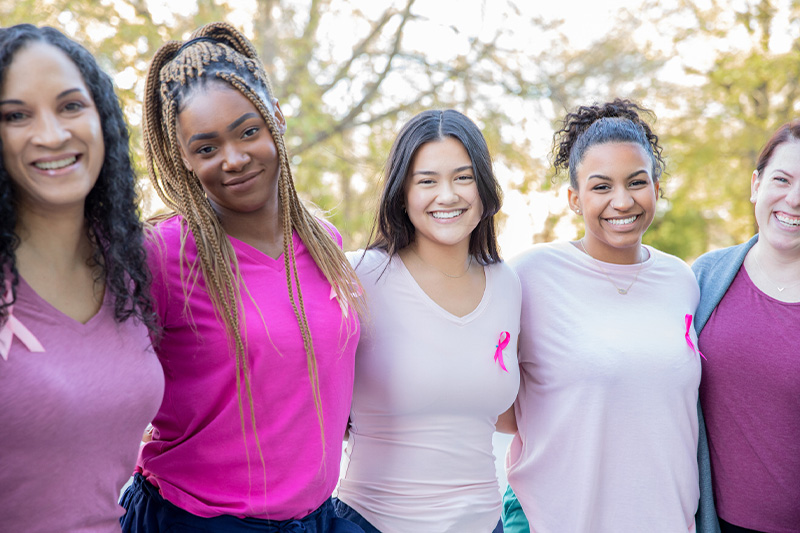 group of women in a line with pink shirts