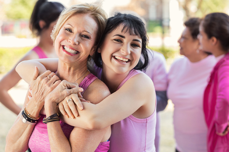 women hugging in pink shirts