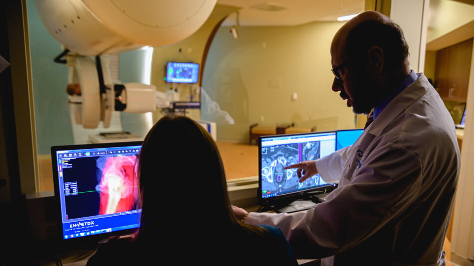 Dr Gayar and staff pointing at monitor